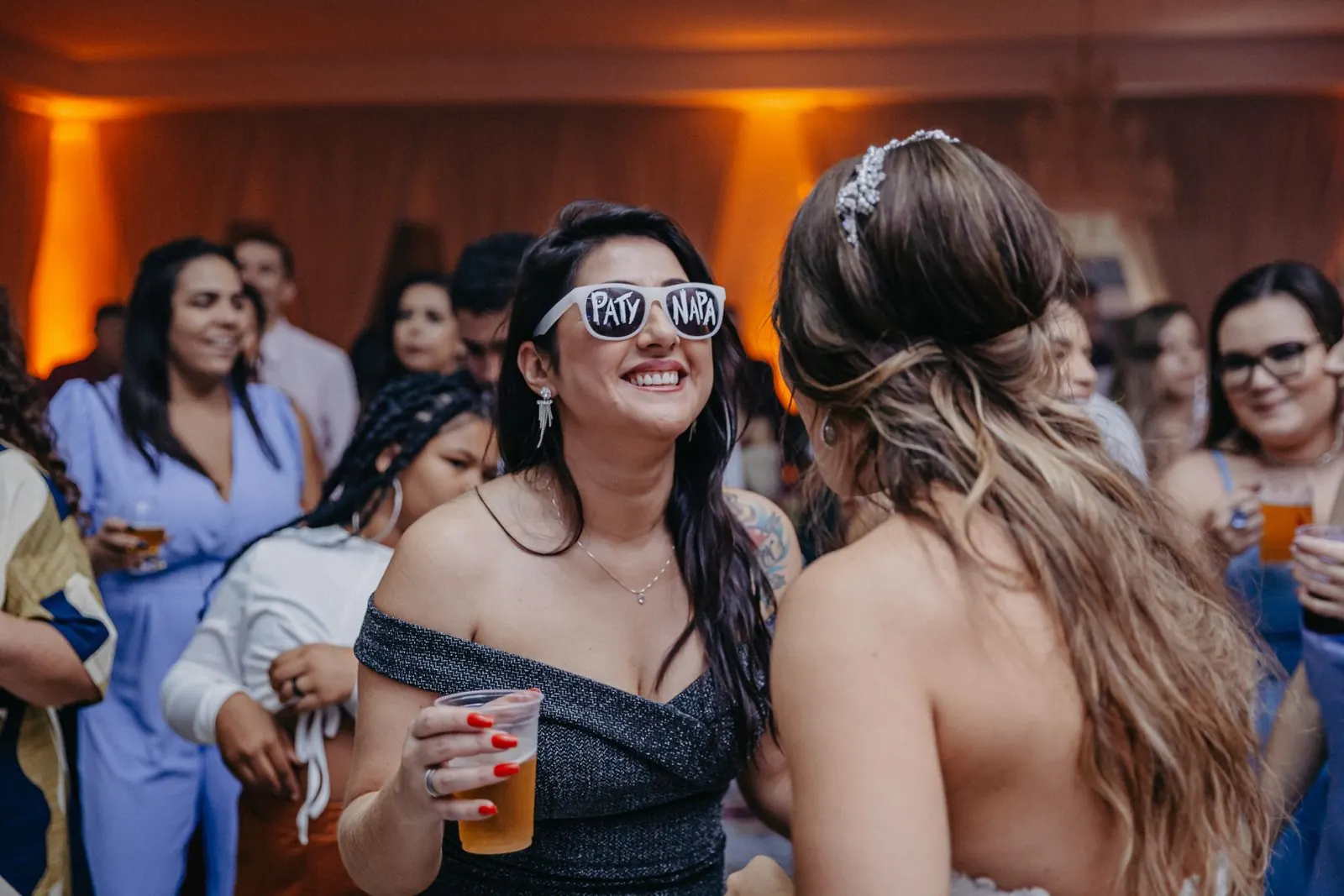 Wedding reception guests in sunglasses having fun at a photo booth